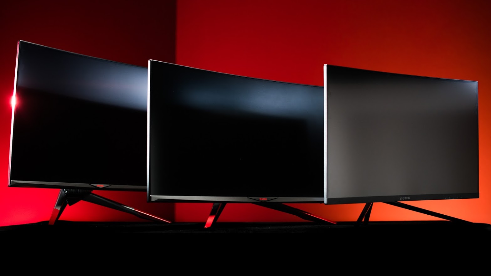 Three Viotek Gaming Monitors in different sizes, angled to the right, behind one another