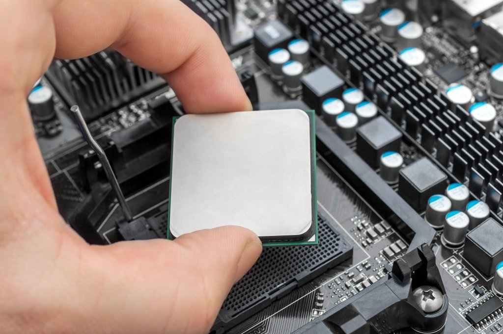 Hand puts computer processor on motherboard.