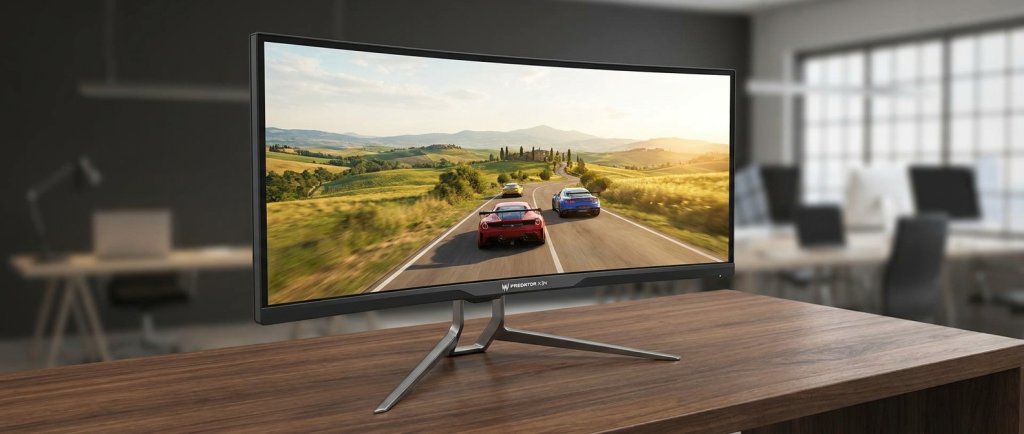 34-inch ultrawide gaming monitor showing panoramic racing game in widescreen format on a modern desk